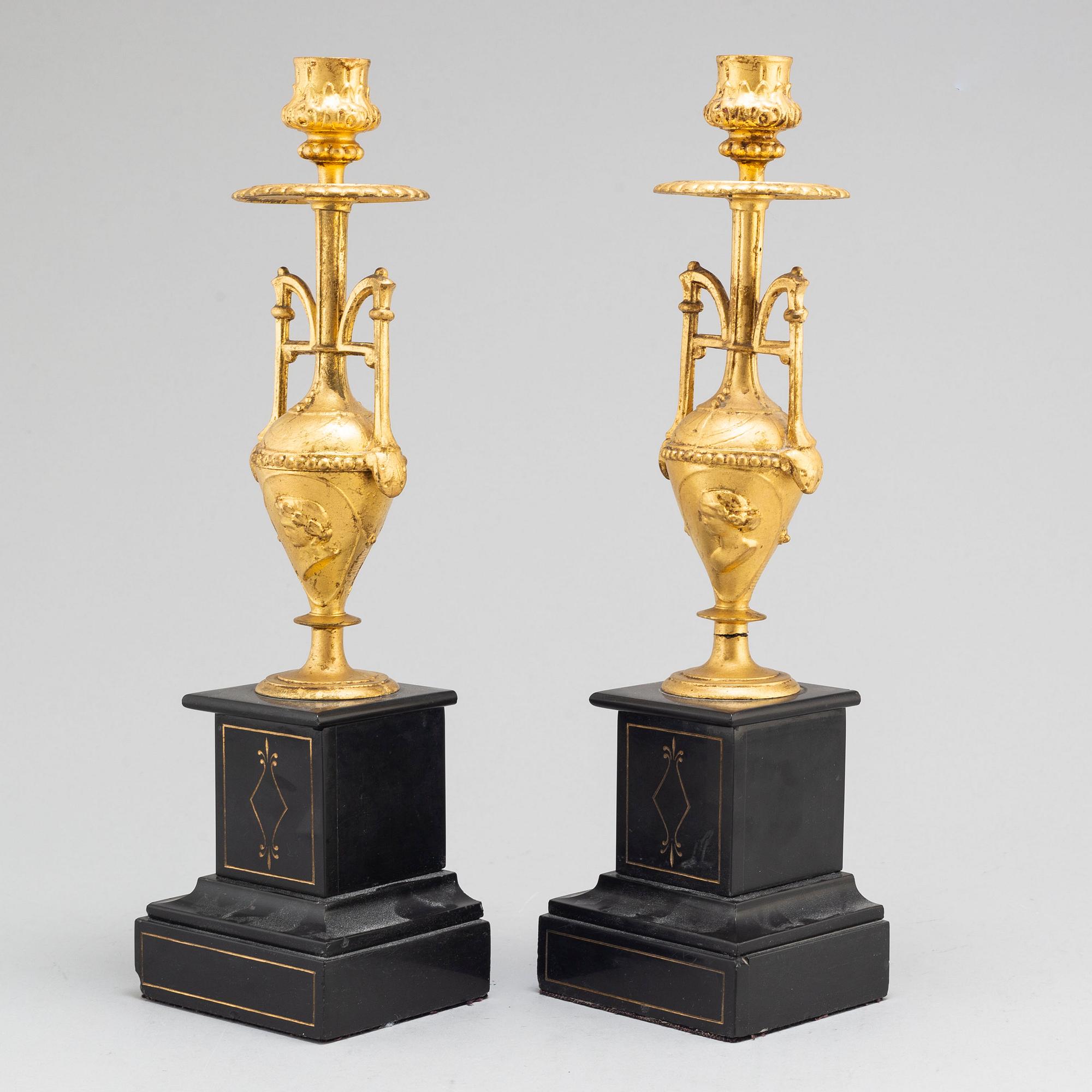 A late 19th century table clock and a pair of candlesticks.