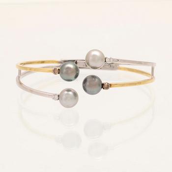 An 18K white- and yellow gold bracelet with round brilliant cut diamonds and cultured Tahitian pearls, Damiani Italy.