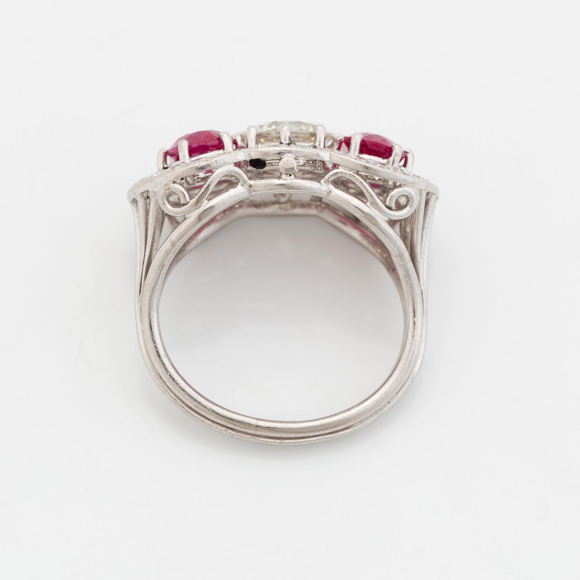 Ring 18K vitguld med fasettslipade rubiner och en rund briljantslipade diamant.