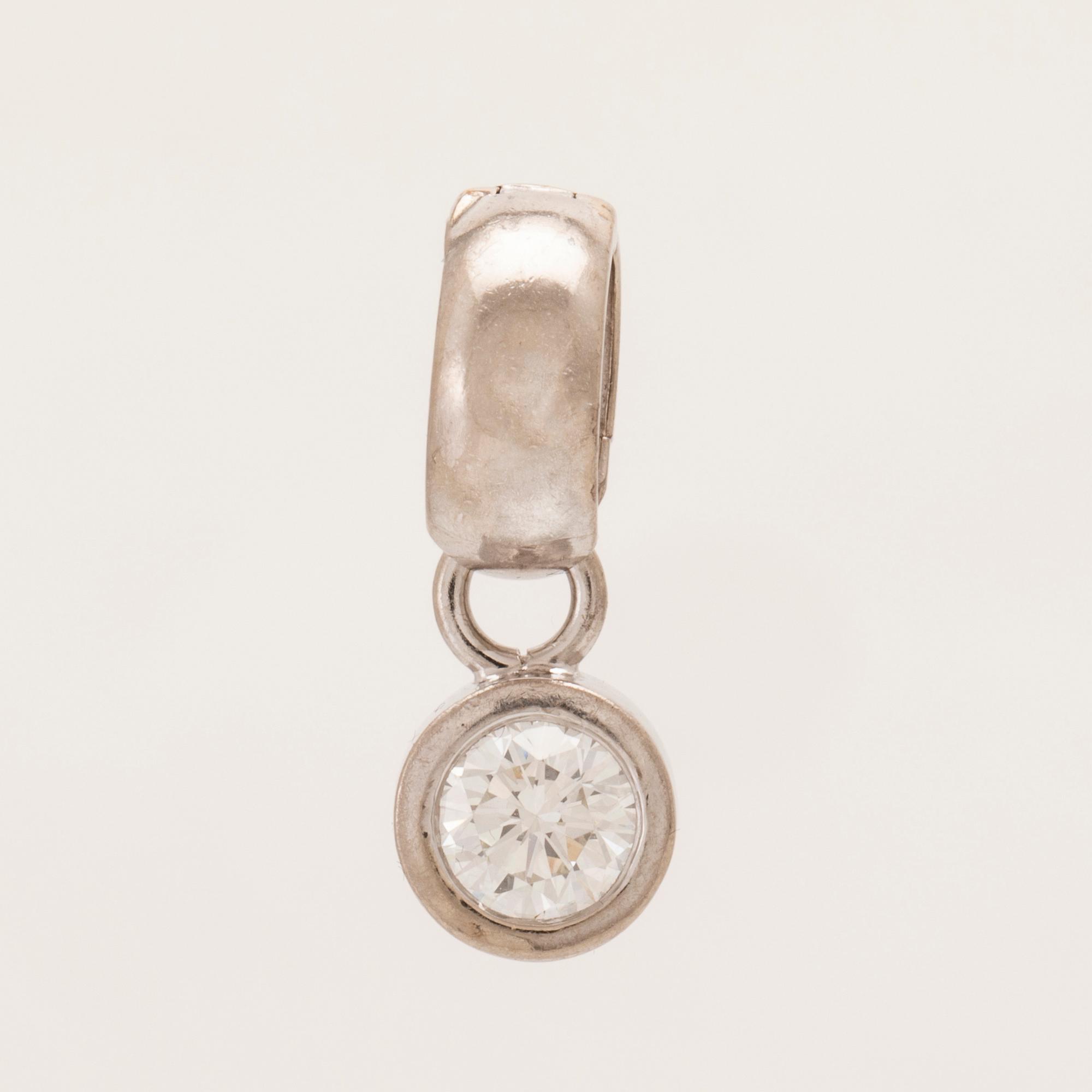 An 18K white gold pendant set with a round brilliant-cut diamond.