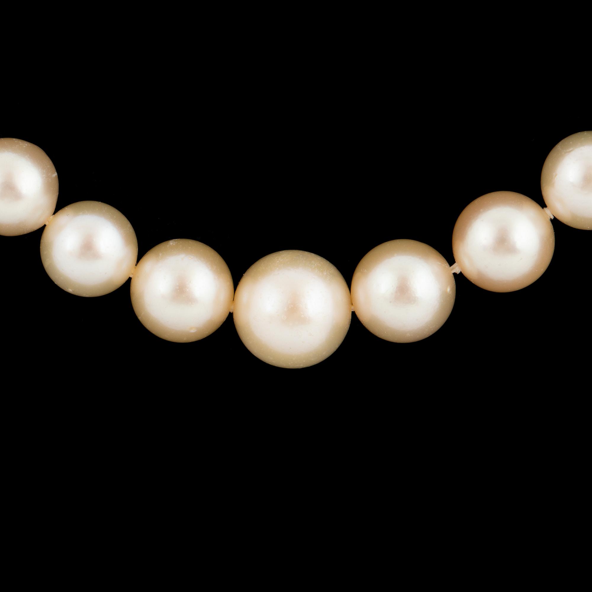 Cultured calibrated pearl necklace, clasp with emerald and old-cut diamonds.