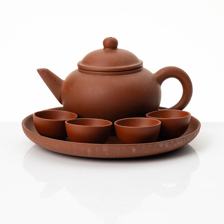 A six part red yixing Gongfu set; teapot, four cups and a tray, China, 1980s.
