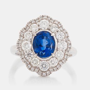 427. A platinum ring set with a faceted sapphire and round brilliant-cut diamonds.