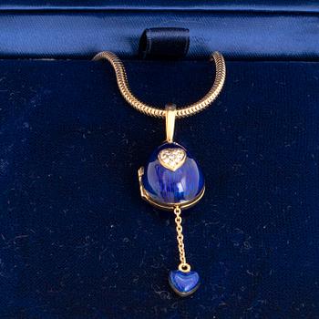 FABERGÉ-ÄGG, 18K guld med blå emalj och runda briljantslipade diamanter, med kedja, med etui.
