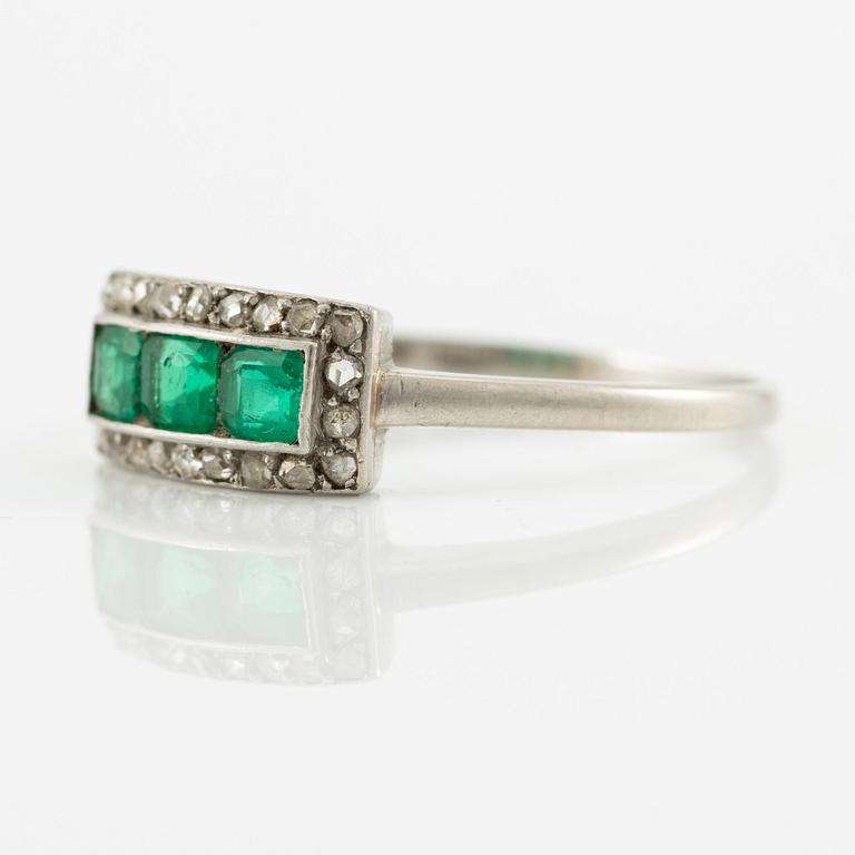 Ring in platinum set with step-cut emeralds and rose-cut diamonds.