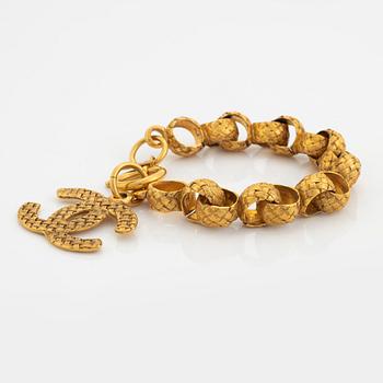 Chanel, a gold tone bracelet.