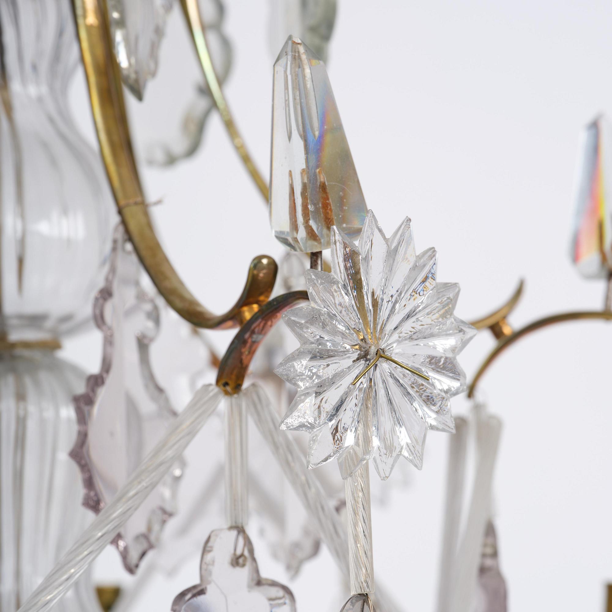 A near pair of rococo-style gilt brass and cut glass six-branch chandeliers, 19th century incorporating older elements.
