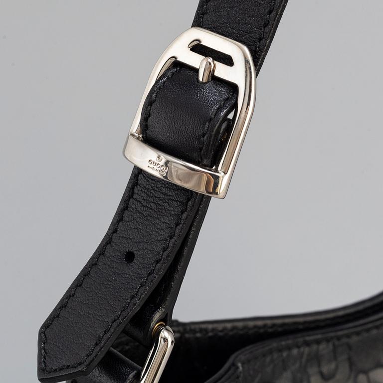 GUCCI, a black leather handbag.