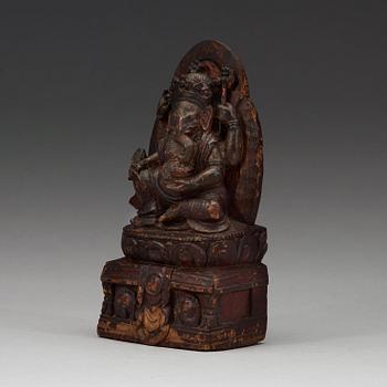 A carved wooden figure on Ganesha on a throne, Nepal, 19th Century or older.