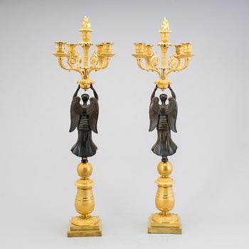 A large pair of first half of the 19th century gilt and patinated bronze five-light candelabra.