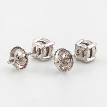 A pair of brilliant cut diamond earrings.