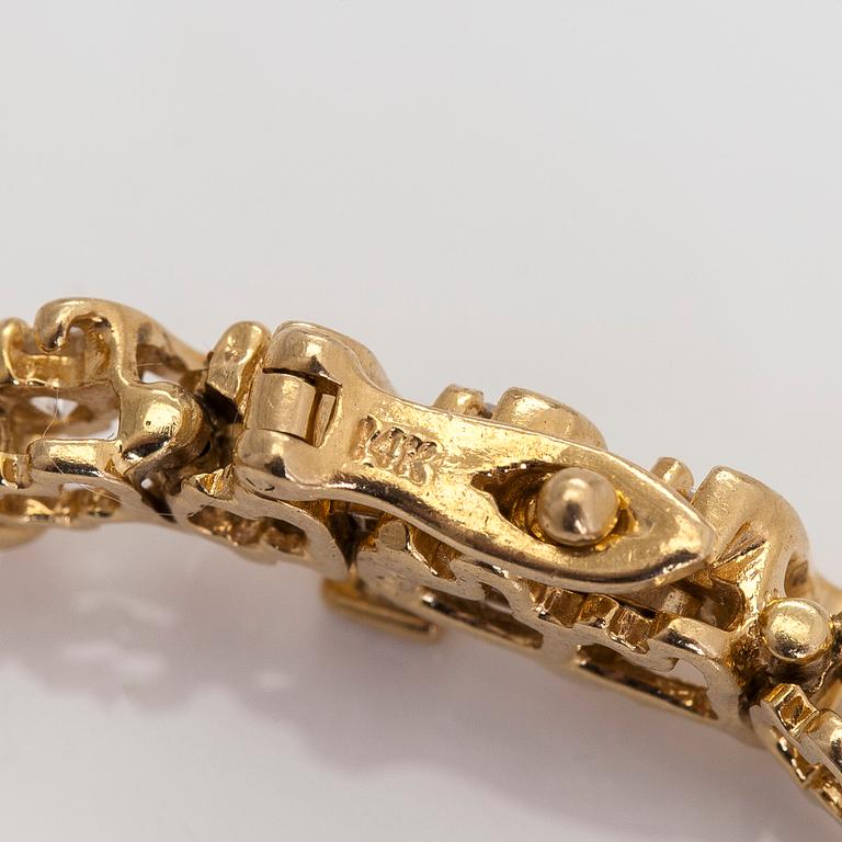 A 14K gold tennis bracelet, with brilliant-cut diamonds.