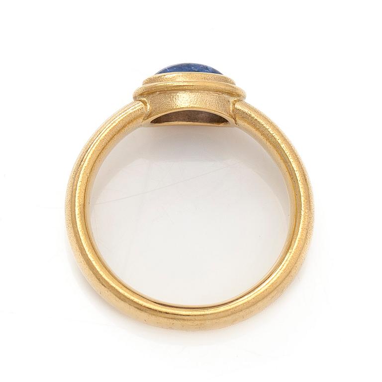 An 18K gold ring with a cabochon-cut sapphire.