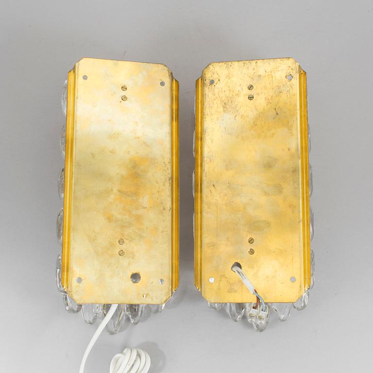 A pair of brass and glass wall lights designed by Carl Fagerlund for Orrefors.