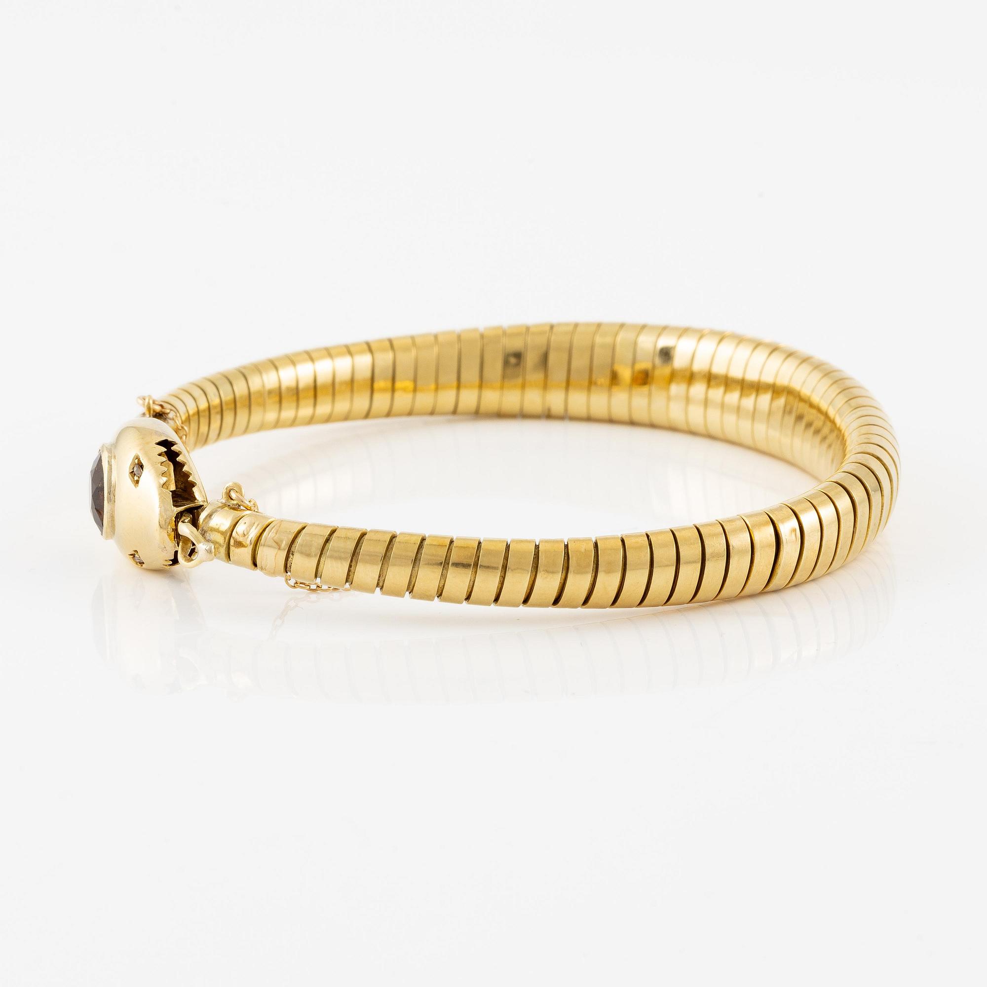 A bracelet in the shape of a serpent in 18K gold with a faceted citrine and rose-cut diamonds.