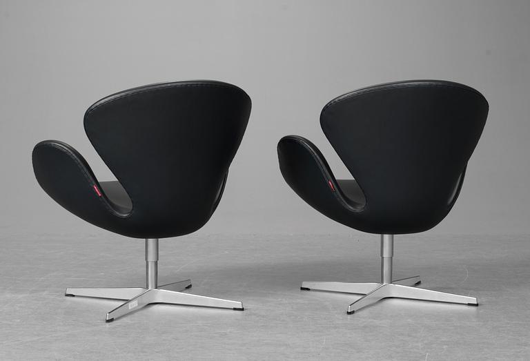 A pair of Arne Jacobsen dark grey leather "Swan Easy Chairs, Fritz Hansen, Denmark 2008.