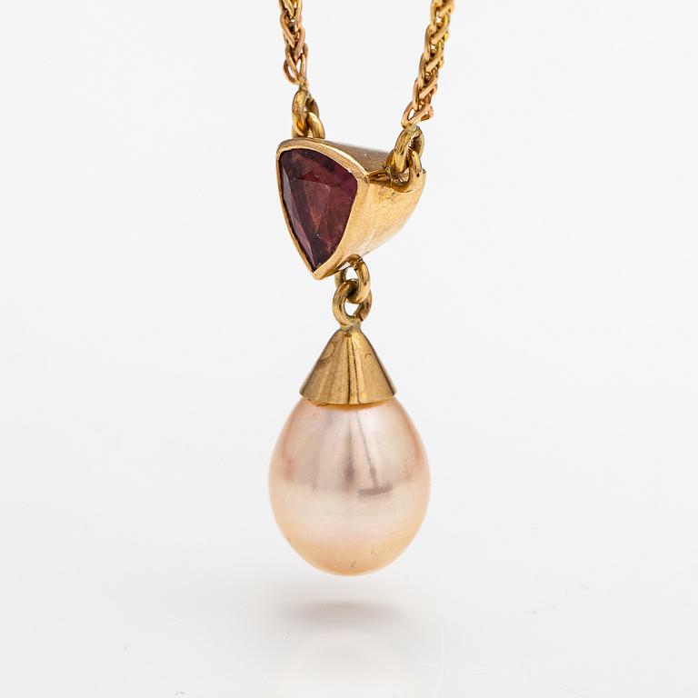 A 14K gold necklace with a tourmaline and cultured pearl.