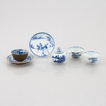 A group of three Chinese porcelain cups, two sacuers and a small teapot, Qing dynasty, 18th century.