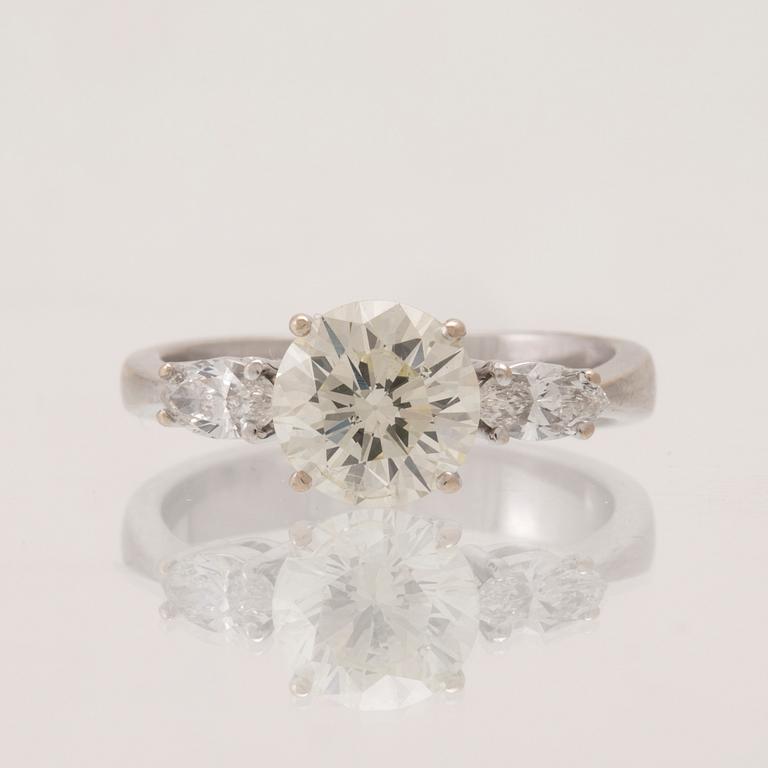 An 18K white gold ring set with one round brilliant-cut diamond and two marquise-cut diamonds.