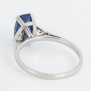 A platinum ring with an octagon scissors cut violetish blue sapphire and triangular-cut diamonds.