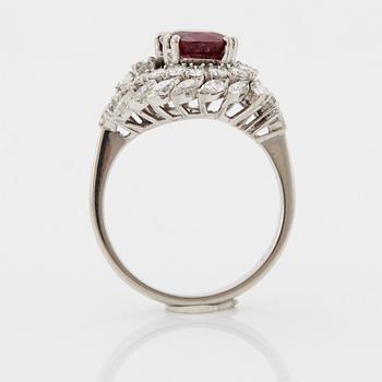 Ring platina med en fasettslipad rubin och runda briljant- och navettslipade diamanter.