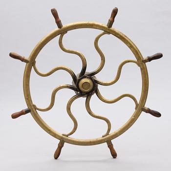 A ship's brass steering wheel, circa 1900.