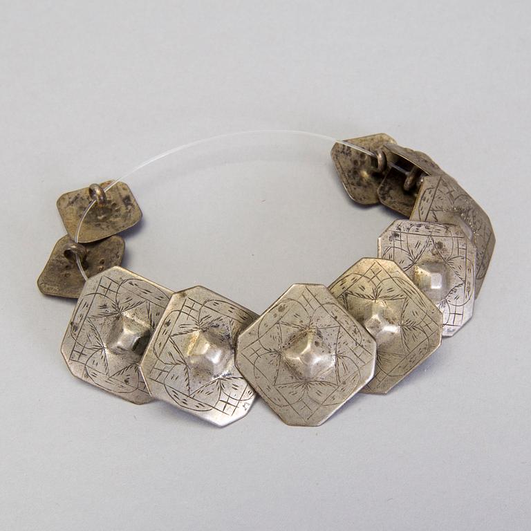 A collection of mostly silver, tradition folk buttons and belt buckles.