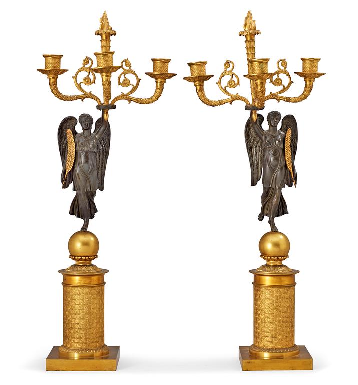 A pair of French Empire early 19th century gilt and patinated bronze three-light candelabra.