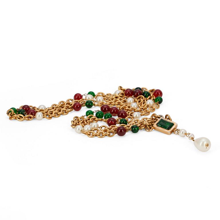 CHANEL, a long gold colored necklace with green and red glass beads as wells as white decorative pearls, not marked.