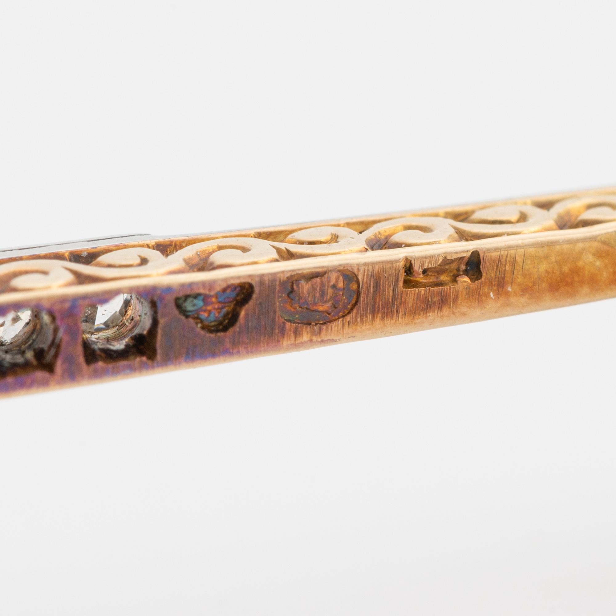 An 18K gold brooch set with a turquoise and old-cut diamonds.