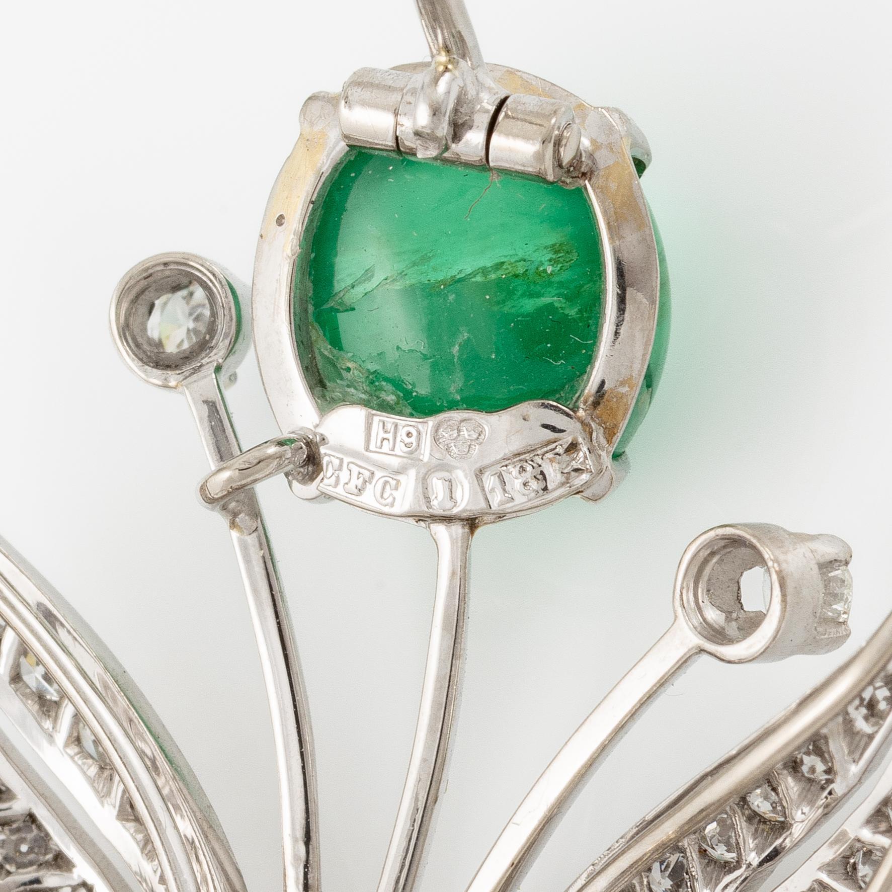 A brooch in 18K white gold with a cabochon-cut emerald.