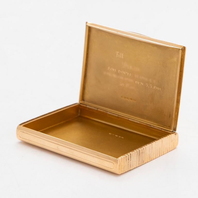 A cigarette case, 18K gold with a synthetic cabochon-cut sapphire. Import marked Wilhelm Pettersson, Turku 1961.