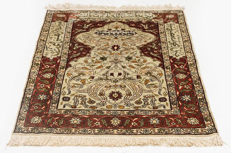 A silk and metal Hereke rug, c. 80 x 51 cm.