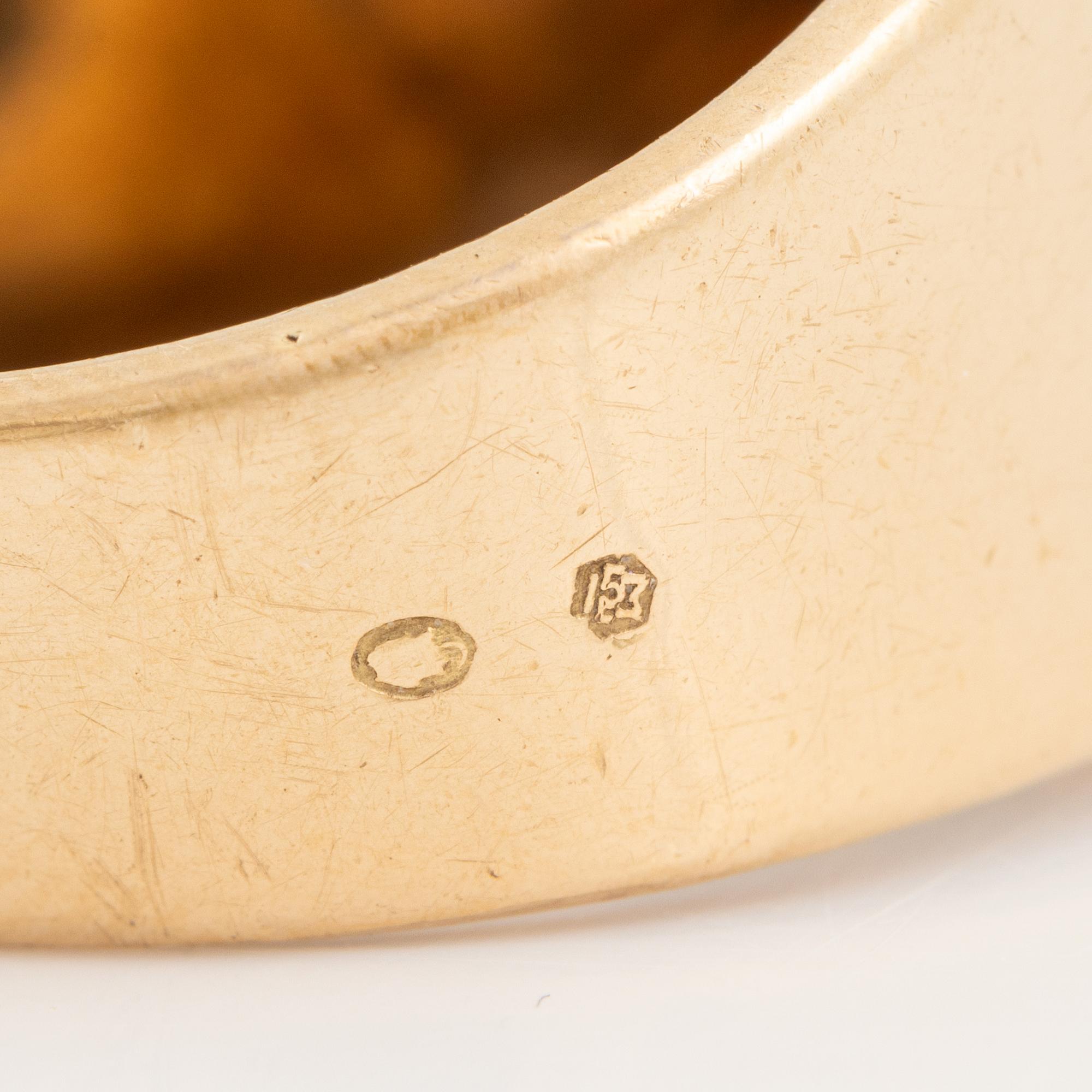 An 18K gold ring set with a faceted sapphire and diamonds.