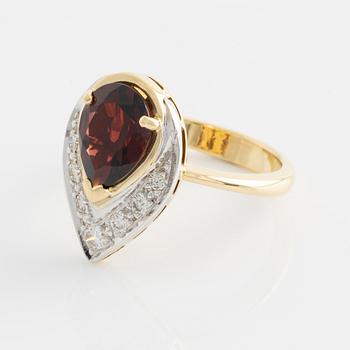 Ring med droppformad granat och briljantslipade diamanter.