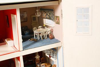 A 1980s doll house with various dolls and furniture.