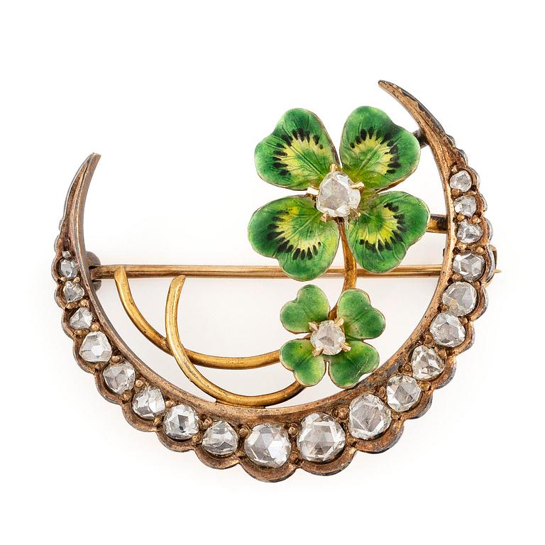 A brooch in the form of a crescent moon in 14K gold  with enamel and rose-cut diamonds.