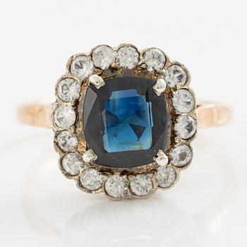 Ring in low carat gold with dark sapphire and white stones.