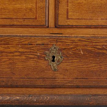 An oak rococo cabinet, mid 18th Century.