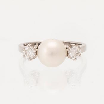 An 18K white gold ring set with a cultured button pearl and round brilliant-cut diamonds, G. Dahlgren & Co Malmö 1961.