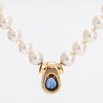 A cultured pearl necklace, pendant in 18K gold with a pearshaped sapphire.