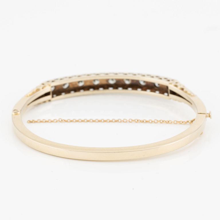 Bangle in 18K gold with round brilliant-cut diamonds.