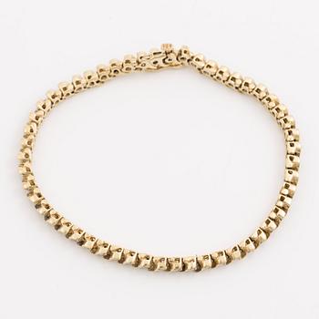 Tennis bracelet 14K gold with round brilliant-cut diamonds.