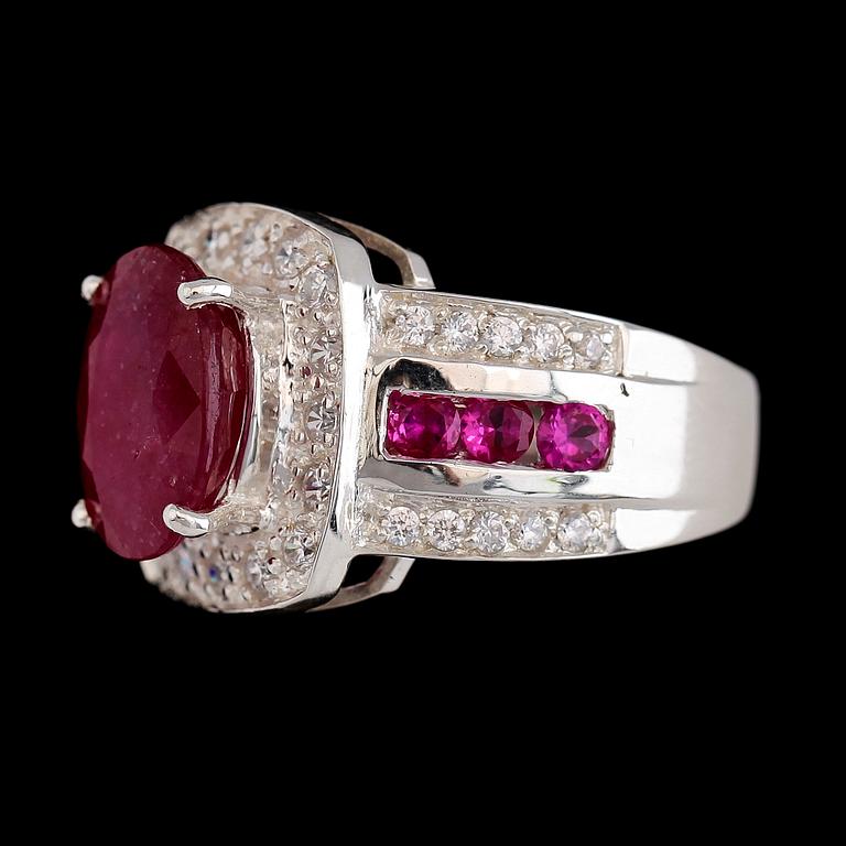 RING, vitguldspläterat sterlingsilver, rubin ca 4.95 ct, vita safirer tot ca 0.30 ct, mindre rubiner tot ca 0.90 ct.