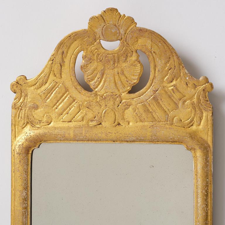 A matched pair of rococo giltwood one-branch girandole mirrors, Stockholm, late 18th century.