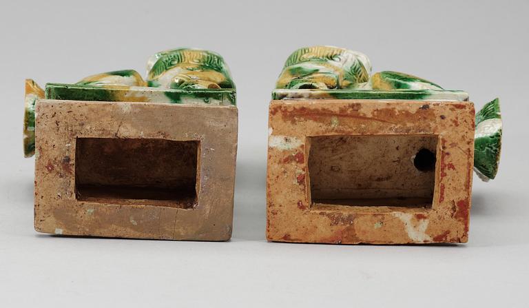 A pair of green and yellow glazed bisquit cencers, in the shape of sitting Buddhist lions, Qing Dynasty, Kangxi (1662-1722).