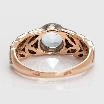 A 14K gold ring with diamonds ca. 0.18 ct in total, and a topaz.