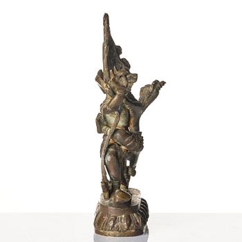 A bronze deity and a brass sacrificial bowl, Tibet, circa 1900.