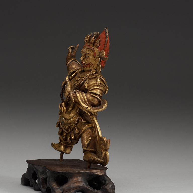 A Sinotibetan gilt bronze  figure of a Dharmapala.