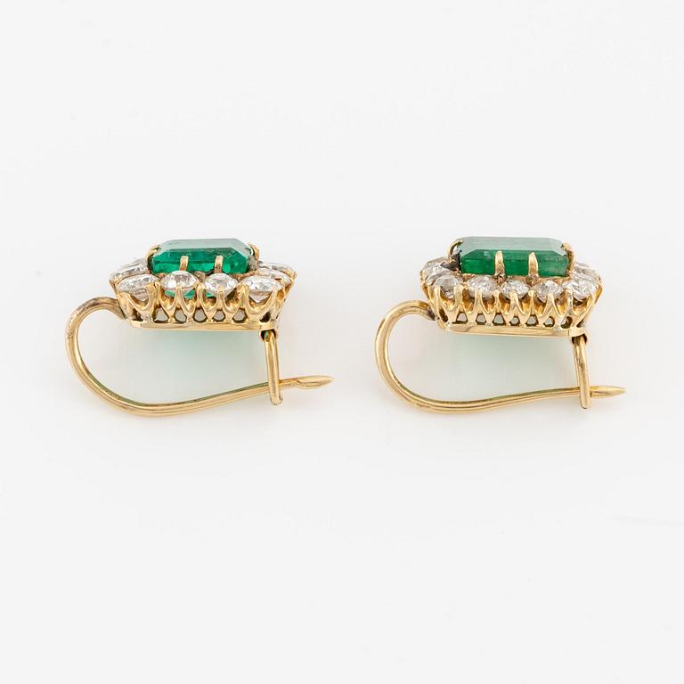 A pair of earrings in 18K gold set with step-cut emeralds and old-cut diamonds.